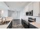 Modern kitchen featuring stainless steel appliances, white cabinets, and a sink at 14251 E 1St Dr # 305, Aurora, CO 80011