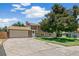 Charming home with a well-manicured lawn and a spacious driveway leading to a two-car garage on a sunny day at 8539 W Duquesne Dr, Lakewood, CO 80227