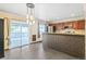 Bright kitchen with sliding glass doors to the deck, stainless appliances, stylish light fixtures, and a decorative half wall at 8539 W Duquesne Dr, Lakewood, CO 80227