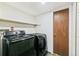 Laundry room featuring a washer, dryer, and shelving at 8539 W Duquesne Dr, Lakewood, CO 80227
