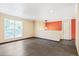 Modern living room with tile floors, an accent wall, a contemporary light fixture, and abundant natural light at 8539 W Duquesne Dr, Lakewood, CO 80227