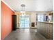 Open-concept living room featuring tile floors, an adjacent kitchen area, and sliding glass doors to the deck at 8539 W Duquesne Dr, Lakewood, CO 80227