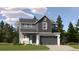 Two-story home featuring gray siding, white stone accents, a front porch, and a two-car garage at 10968 Snowdon St, Parker, CO 80134