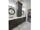 Double vanity bathroom with tall cabinetry and circular mirrors at 106 S University Blvd # 5, Denver, CO 80209