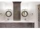 Elegant bathroom featuring double sinks with dark cabinetry, white countertops, and round mirrors at 106 S University Blvd # 5, Denver, CO 80209