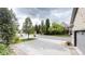 View of driveway leading to a luxury estate with mature landscaping and a gated entrance at 106 S University Blvd # 5, Denver, CO 80209