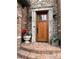 Close-up of a stately wooden front door with stone and brick accents and decorative planters at 106 S University Blvd # 5, Denver, CO 80209