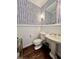 Stylish powder room with herringbone patterned wallpaper and pedestal sink at 106 S University Blvd # 5, Denver, CO 80209