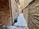 Brick wall and snowy walkway alongside home at 106 S University Blvd # 5, Denver, CO 80209