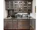 Stylish wet bar with granite countertops, wine fridge, and glass-front cabinets for elegant storage at 106 S University Blvd # 5, Denver, CO 80209