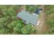 Aerial view of a home with a gray roof nestled among tall pine trees with a driveway at 7597 Molas Ct, Larkspur, CO 80118