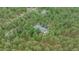 Aerial view of a home nestled among tall pine trees in a wooded community at 7597 Molas Ct, Larkspur, CO 80118
