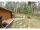 Landscaped backyard features a stone patio and lush green lawn surrounded by mature trees at 7597 Molas Ct, Larkspur, CO 80118