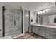 Bright bathroom featuring a glass shower, wood-look floors, and a grey vanity with granite countertops at 7597 Molas Ct, Larkspur, CO 80118