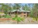 Wood and stone home with rock landscaping and a brick retaining wall in a wooded area at 7597 Molas Ct, Larkspur, CO 80118