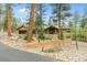 Stunning wood and stone home with rock landscaping and a brick retaining wall in a wooded area at 7597 Molas Ct, Larkspur, CO 80118