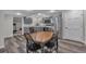 Lovely kitchen with stainless steel appliances, gray cabinetry and wood floors and a dining table at 7597 Molas Ct, Larkspur, CO 80118