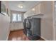 Well-lit laundry room features modern washer and dryer, white cabinetry, and a large window at 7597 Molas Ct, Larkspur, CO 80118