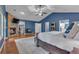 This main bedroom features blue walls, hardwood floors, a stone fireplace, and an ensuite bathroom at 7597 Molas Ct, Larkspur, CO 80118