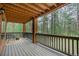 Spacious covered porch with wood beam ceiling offers relaxing views of the surrounding forest at 7597 Molas Ct, Larkspur, CO 80118