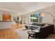 Open living room with hardwood floors, gray sectional sofa, and kitchen views at 2975 Thunder Lake Cir, Lafayette, CO 80026