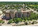 Expansive aerial view of a brick condominium featuring mature trees and well-manicured landscaping at 2400 E Cherry Creek South Dr # 307, Denver, CO 80209