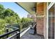 Relaxing brick balcony with wrought iron railing featuring cushioned seating and views of mature trees and landscaping at 2400 E Cherry Creek South Dr # 307, Denver, CO 80209