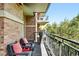 Cozy balcony with lounge chairs, brick siding, and wrought iron railings perfect for relaxing outdoors at 2400 E Cherry Creek South Dr # 307, Denver, CO 80209