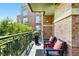 Spacious outdoor balcony with brick accent wall offering comfortable seating and views of lush landscaping at 2400 E Cherry Creek South Dr # 307, Denver, CO 80209