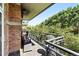 Private balcony with brick siding, black wrought iron railing and views of green trees and landscaping at 2400 E Cherry Creek South Dr # 307, Denver, CO 80209