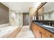 Luxurious bathroom featuring a soaking tub, glass-enclosed shower, and double sink vanity with granite countertops at 2400 E Cherry Creek South Dr # 307, Denver, CO 80209