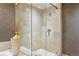Bathroom featuring a glass-enclosed shower with neutral tile and modern fixtures at 2400 E Cherry Creek South Dr # 307, Denver, CO 80209