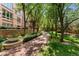 Serene brick walkway lined with lush greenery and mature trees, offering a peaceful outdoor experience at 2400 E Cherry Creek South Dr # 307, Denver, CO 80209