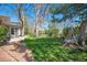Landscaped backyard with mature trees, stone patio, and bench swing at 10490 W 78Th Ave, Arvada, CO 80005