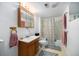 Full bathroom with a shower-tub combo, vanity, decorative mirror, and patterned rug at 10490 W 78Th Ave, Arvada, CO 80005
