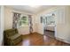 Cozy bedroom featuring hardwood floors, floral curtains, and an open layout connected to another room at 10490 W 78Th Ave, Arvada, CO 80005