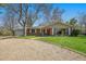 Quaint brick home with a well-maintained lawn and a long, private gravel driveway at 10490 W 78Th Ave, Arvada, CO 80005
