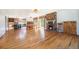 Spacious living room with hardwood floors, brick fireplace, and adjacent kitchen and dining areas at 10490 W 78Th Ave, Arvada, CO 80005