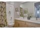 Bathroom featuring a double vanity, tiled shower with decorative curtain, and neutral wall decor at 1031 Turnberry Cir, Louisville, CO 80027