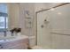 Bright bathroom features a single vanity, tiled shower with glass door, and decorative paintings at 1031 Turnberry Cir, Louisville, CO 80027