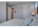 Well-lit bedroom showcasing neutral tones, including a gray wall, and a glimpse into an adjoining space at 1031 Turnberry Cir, Louisville, CO 80027