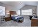 Bright bedroom features vaulted ceiling, neutral walls and carpet, wood headboard, and plenty of natural light at 1031 Turnberry Cir, Louisville, CO 80027