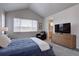 Bright bedroom features vaulted ceiling and large window, neutral walls and carpet, and wood dresser at 1031 Turnberry Cir, Louisville, CO 80027