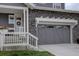 Close-up of the home's gray two-car garage with a decorative pergola and stone detailing at 1031 Turnberry Cir, Louisville, CO 80027