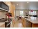 Well-appointed kitchen with stainless steel appliances, light wood cabinets, and seamless integration into the living spaces at 1031 Turnberry Cir, Louisville, CO 80027