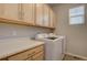 Laundry room with upper cabinets, counter space, and modern washer and dryer for convenience at 1031 Turnberry Cir, Louisville, CO 80027