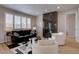 Comfortable living room with a modern fireplace, bright windows, and a stylish black leather sofa at 1031 Turnberry Cir, Louisville, CO 80027