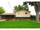 Backyard featuring a lush lawn, mature trees, and a charming covered patio area at 11823 Williams Way, Northglenn, CO 80233