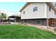 Well-maintained backyard with lush lawn, brick accents, and a covered patio area at 11823 Williams Way, Northglenn, CO 80233