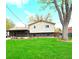 Spacious backyard with lush lawn, mature tree, and charming two-story home at 11823 Williams Way, Northglenn, CO 80233